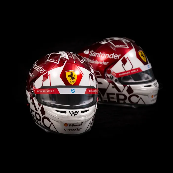 Dois capacetes réplica Ferrari em vermelho e branco sobre fundo preto