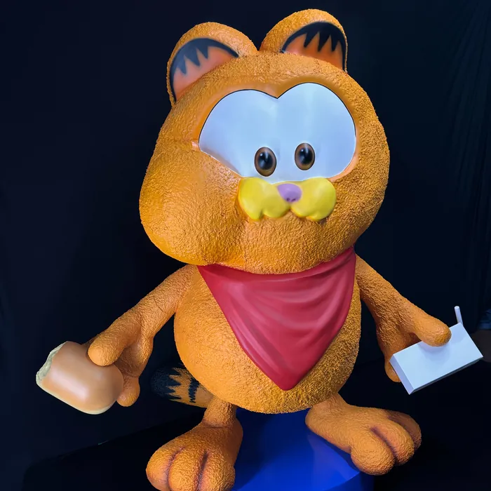 Estátua do Garfield com bandana vermelha sobre base azul